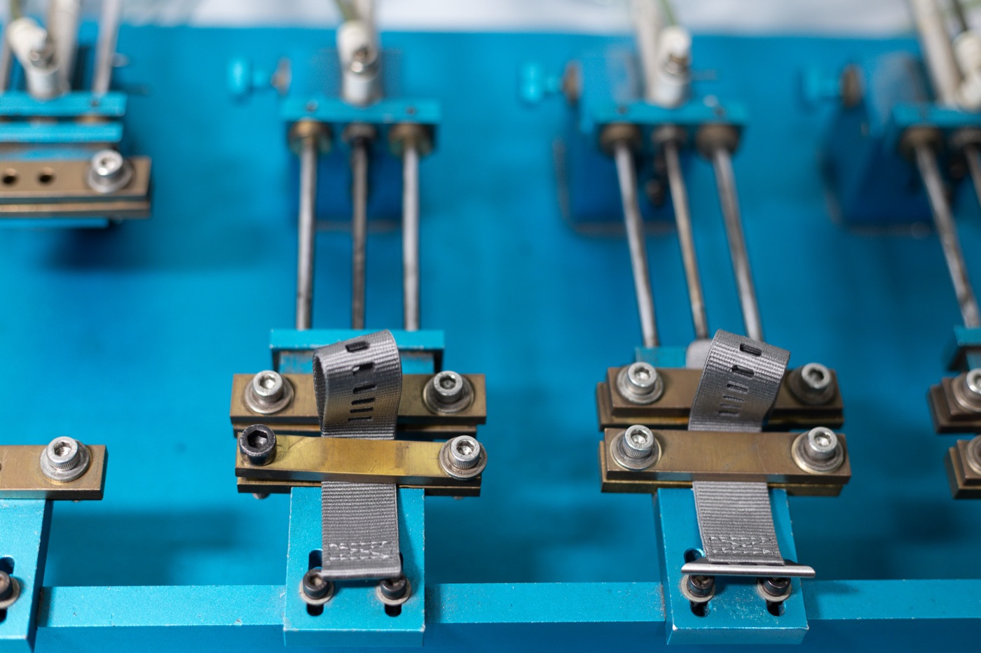 Straps clamped into a multi-station durability rig.