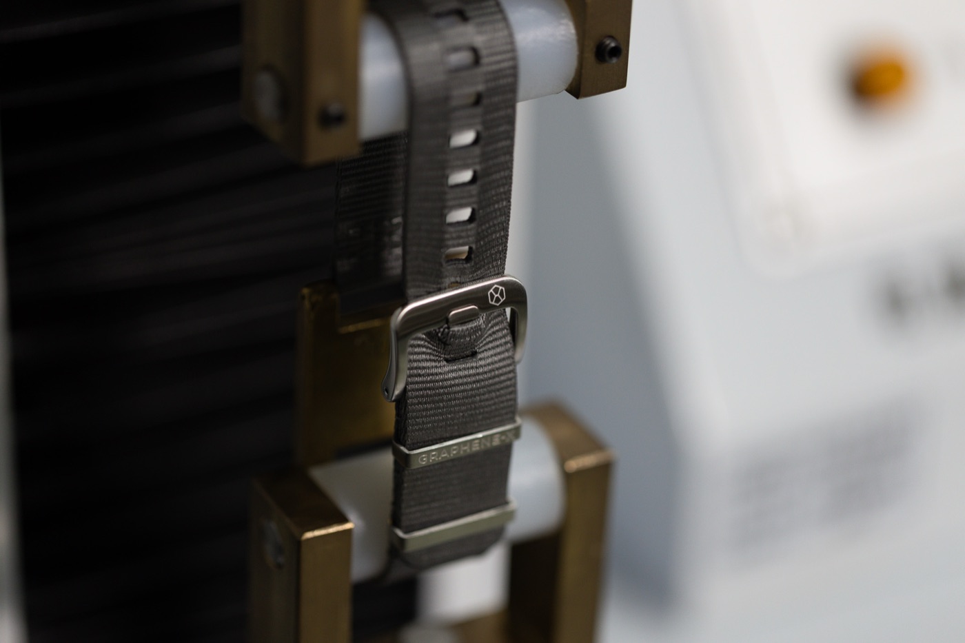 A Lattice strap held in the jaws of a tensile testing rig.